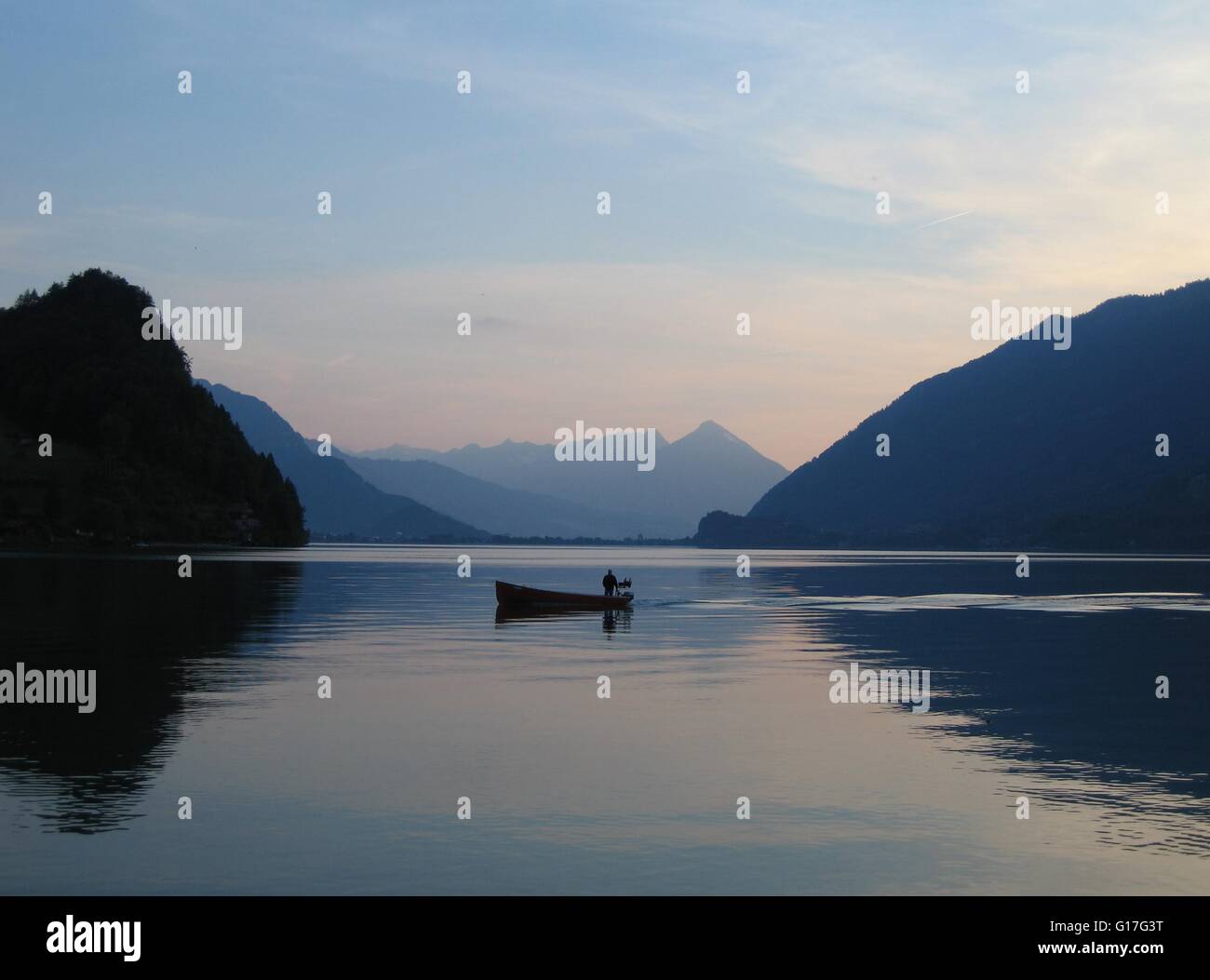 Einsamen Fischer im kleinen Boot am Brienzersee, Schweiz bei Sonnenuntergang Stockfoto