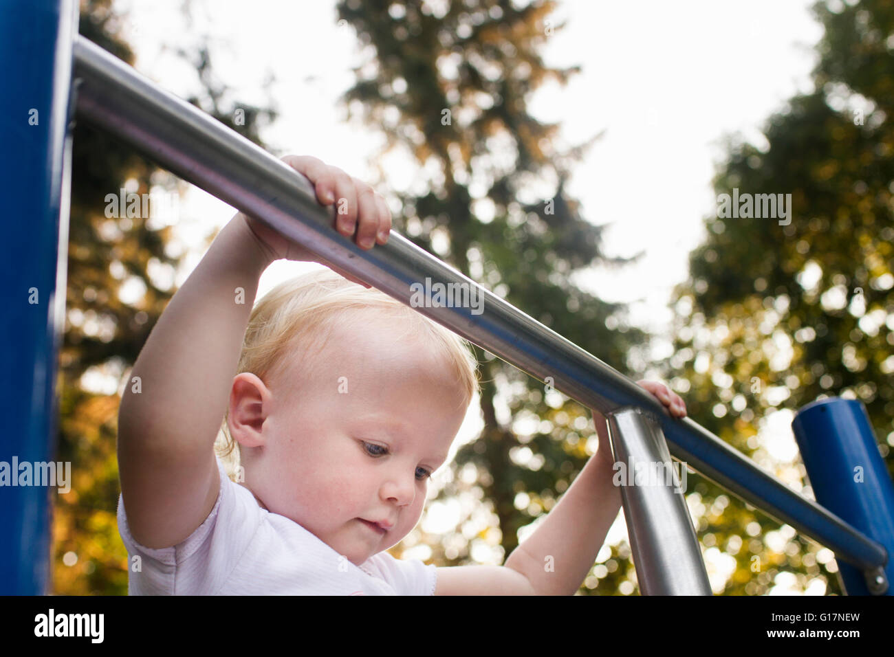 Babymädchen auf Klettergerüst im park Stockfoto