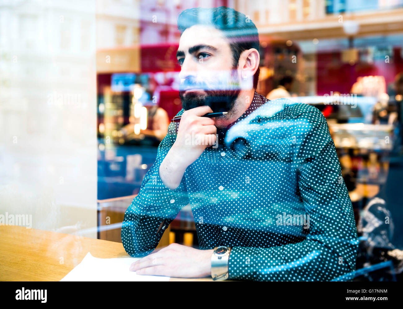 Geschäftsmann, sitzen im Café Papierkram zu tun und den Blick durch Fenster Stockfoto