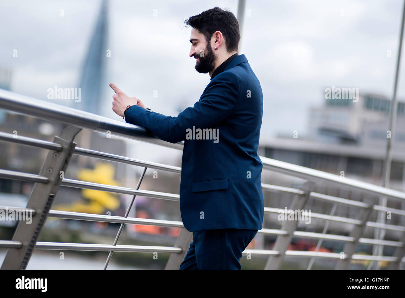 Geschäftsmann am Steg lesen Smartphone Text, London, UK Stockfoto
