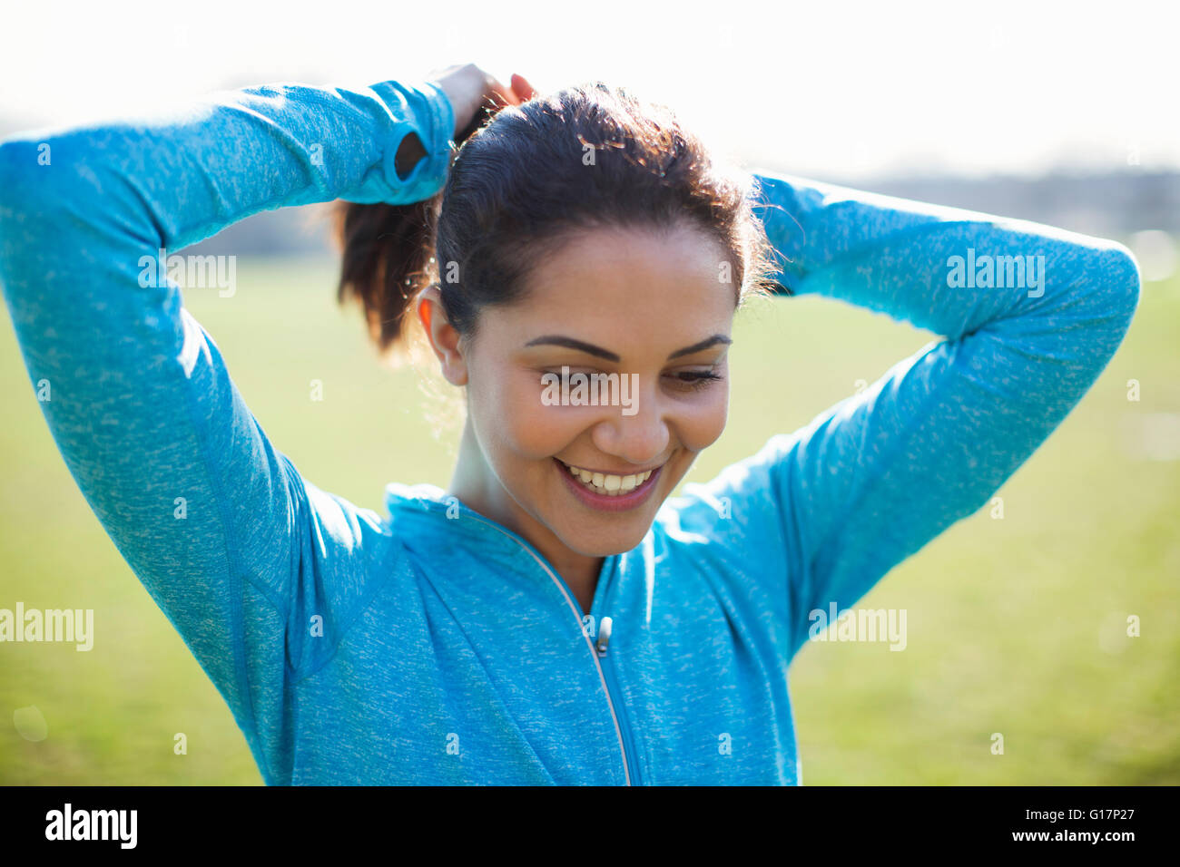 Junge Frau, Ausbildung, Haar-Styling zu Pferdeschwanz im park Stockfoto