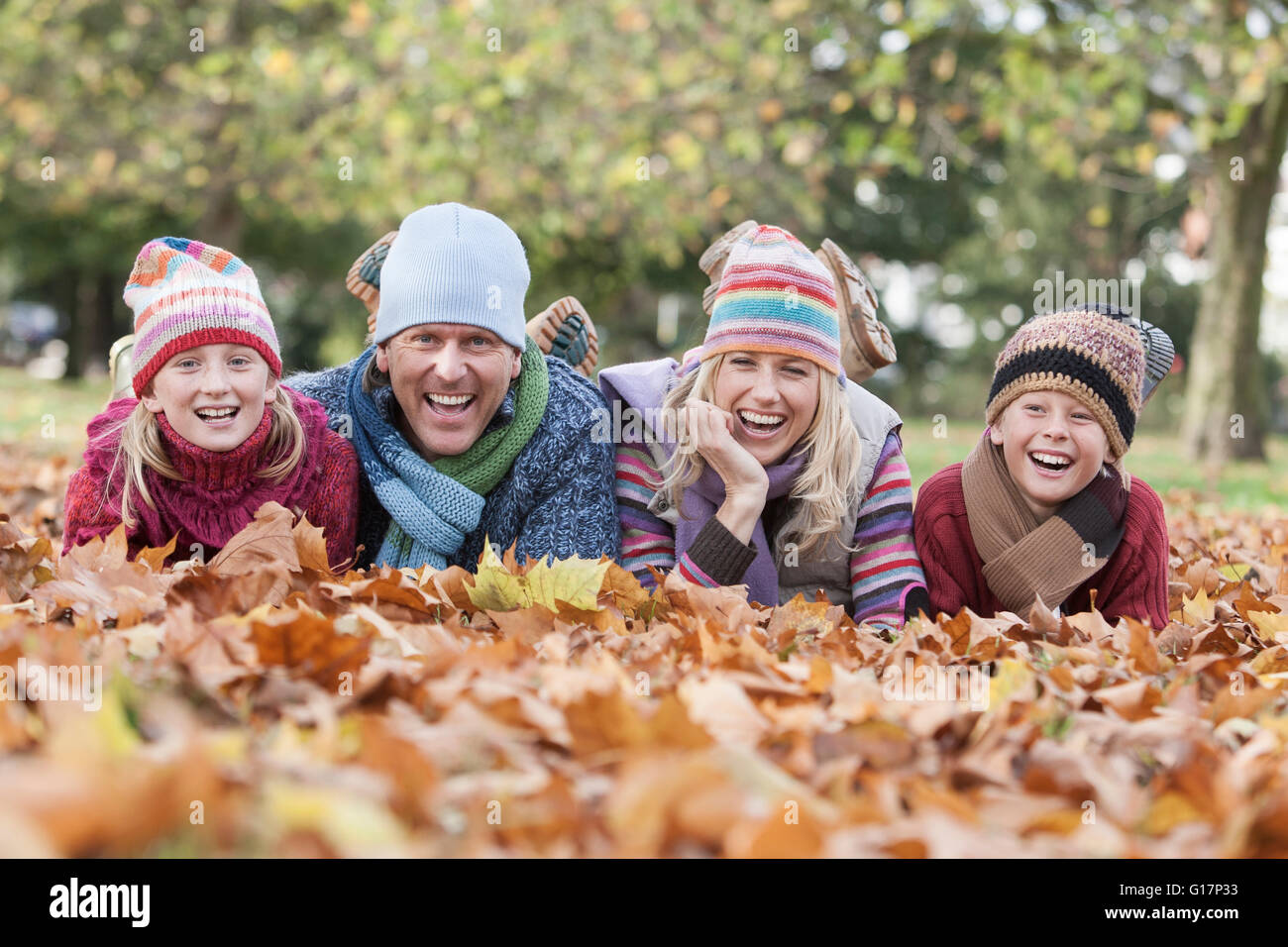 Porträt der Familie, liegend im Herbstlaub, lachen Stockfoto