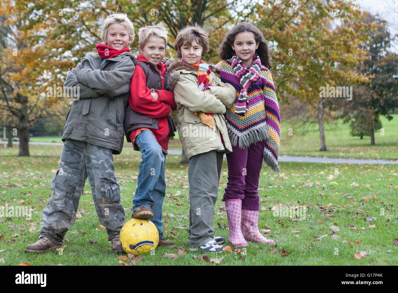 Porträt von vier Kindern mit Fußball im park Stockfoto