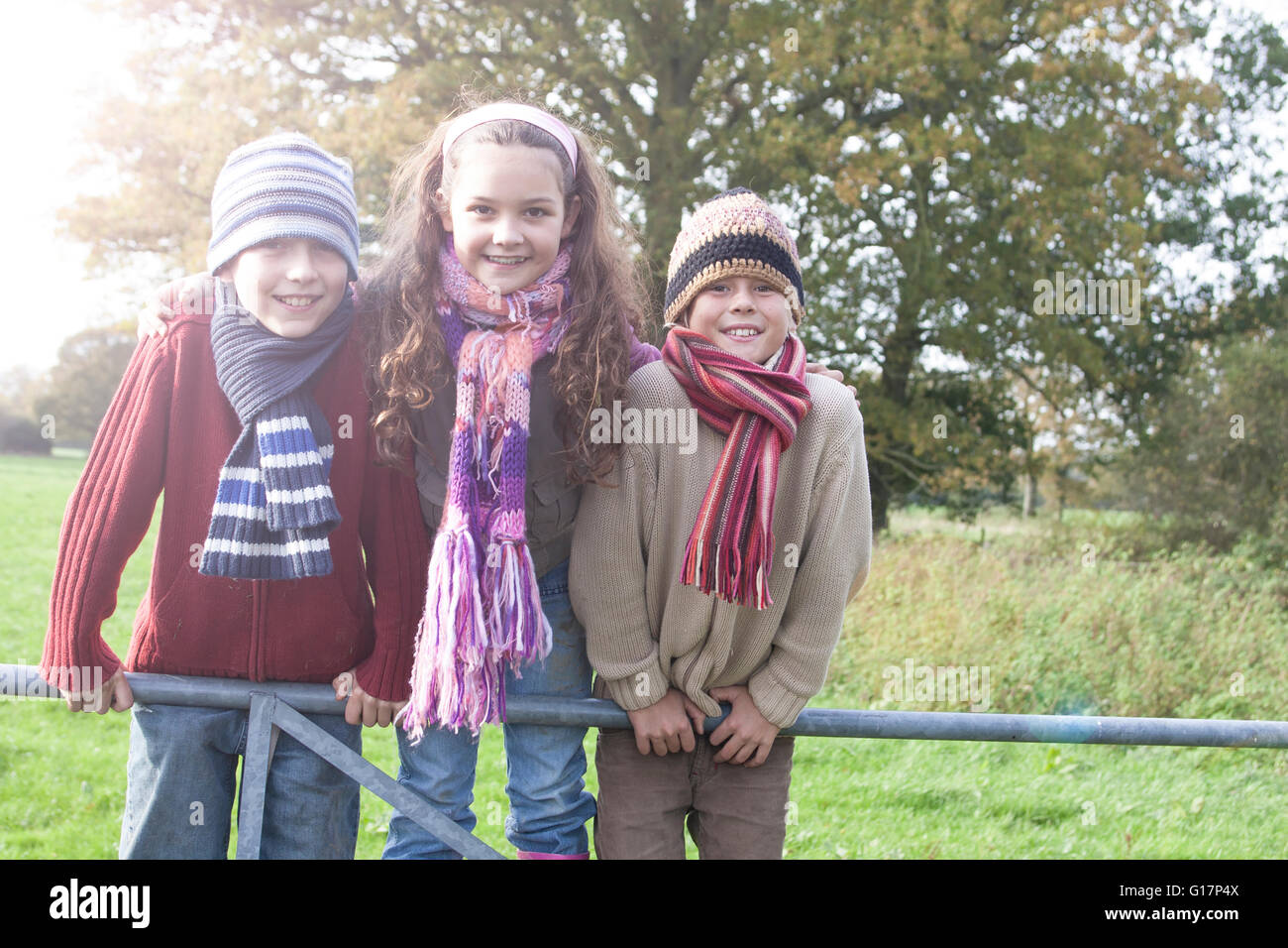 Porträt von drei Kindern, stützte sich auf Zaun, Lächeln Stockfoto