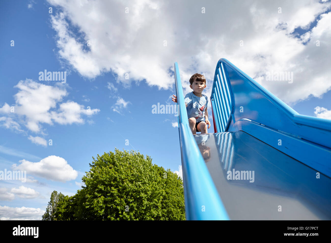 Junge an Spitze der Rutschbahn Stockfoto