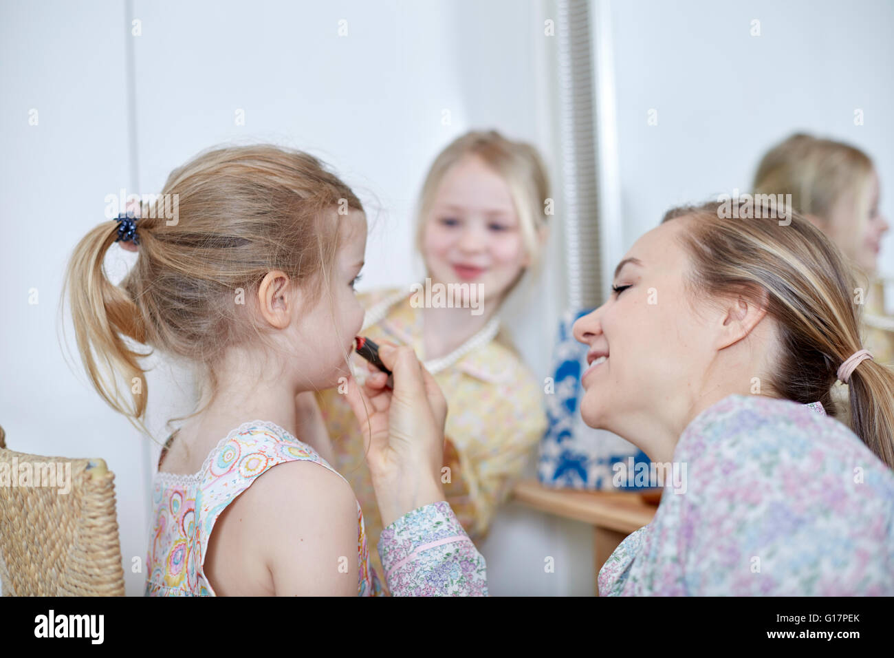 Mutter und Töchter spielen Dress-Up im Schlafzimmer Stockfoto