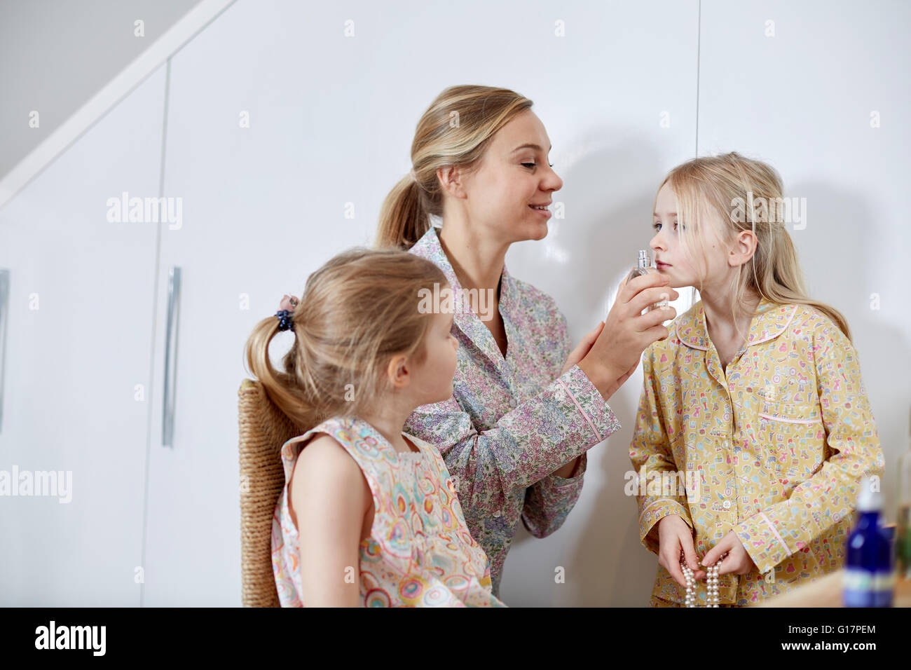 Mutter und Töchter spielen Dress-Up im Schlafzimmer Stockfoto