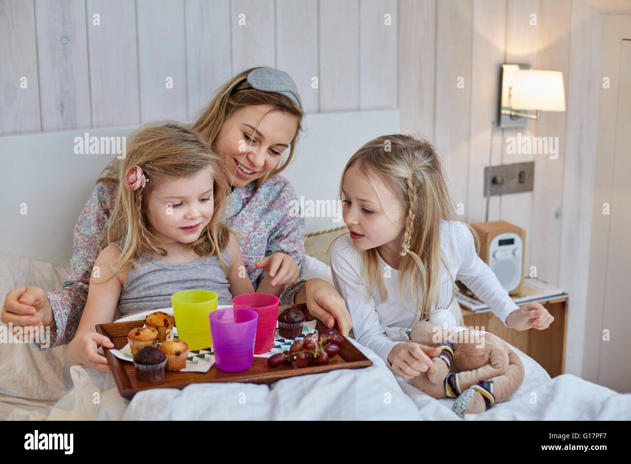 Mutter und Töchter mit Frühstück im Bett Stockfoto