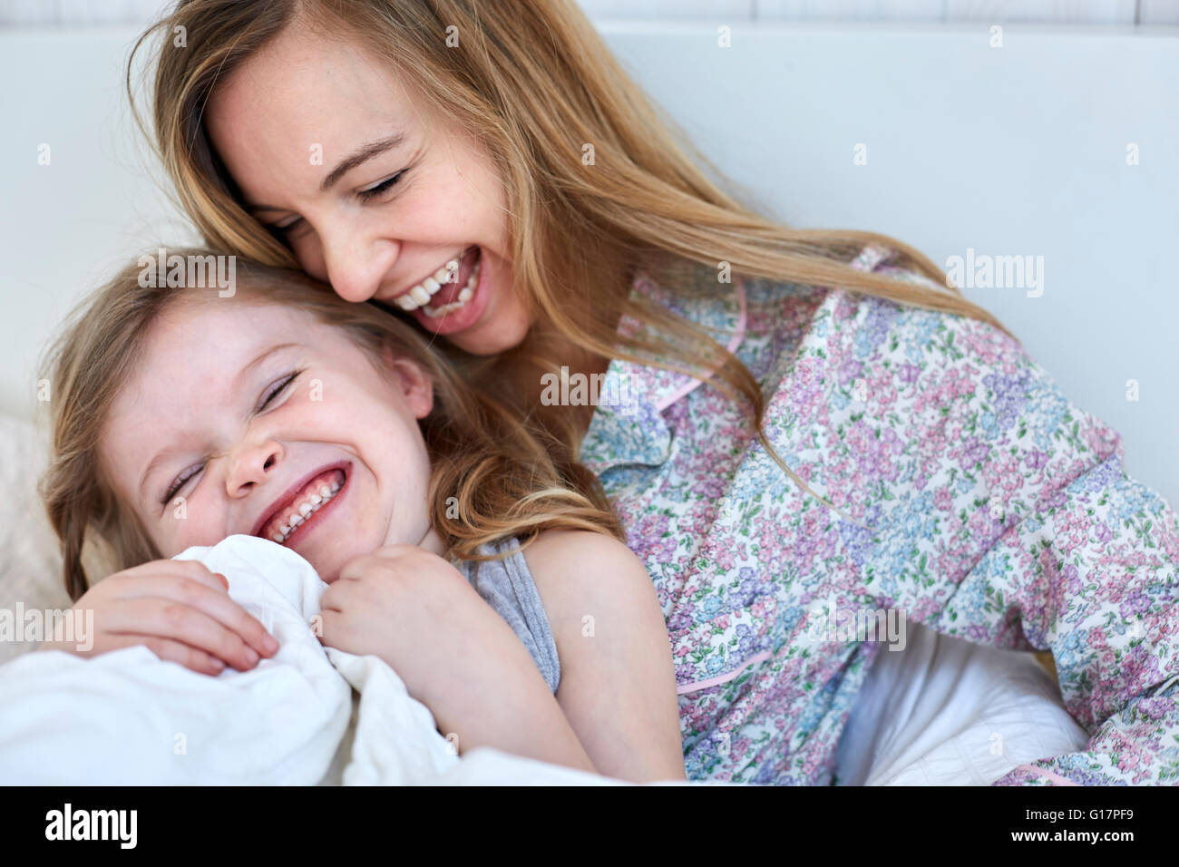 Mutter und Tochter im Bett lachen Stockfoto