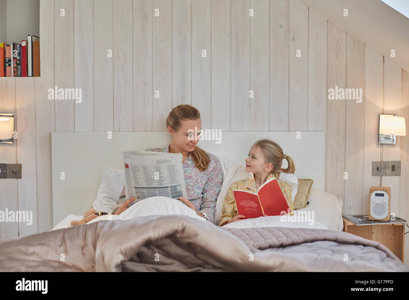 Mutter und Tochter im Bett lesen Stockfoto