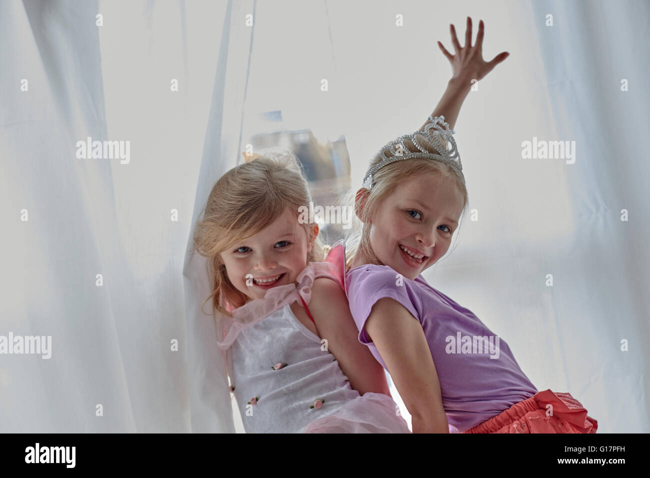 Mädchen in Tracht posiert neben Vorhänge Stockfoto