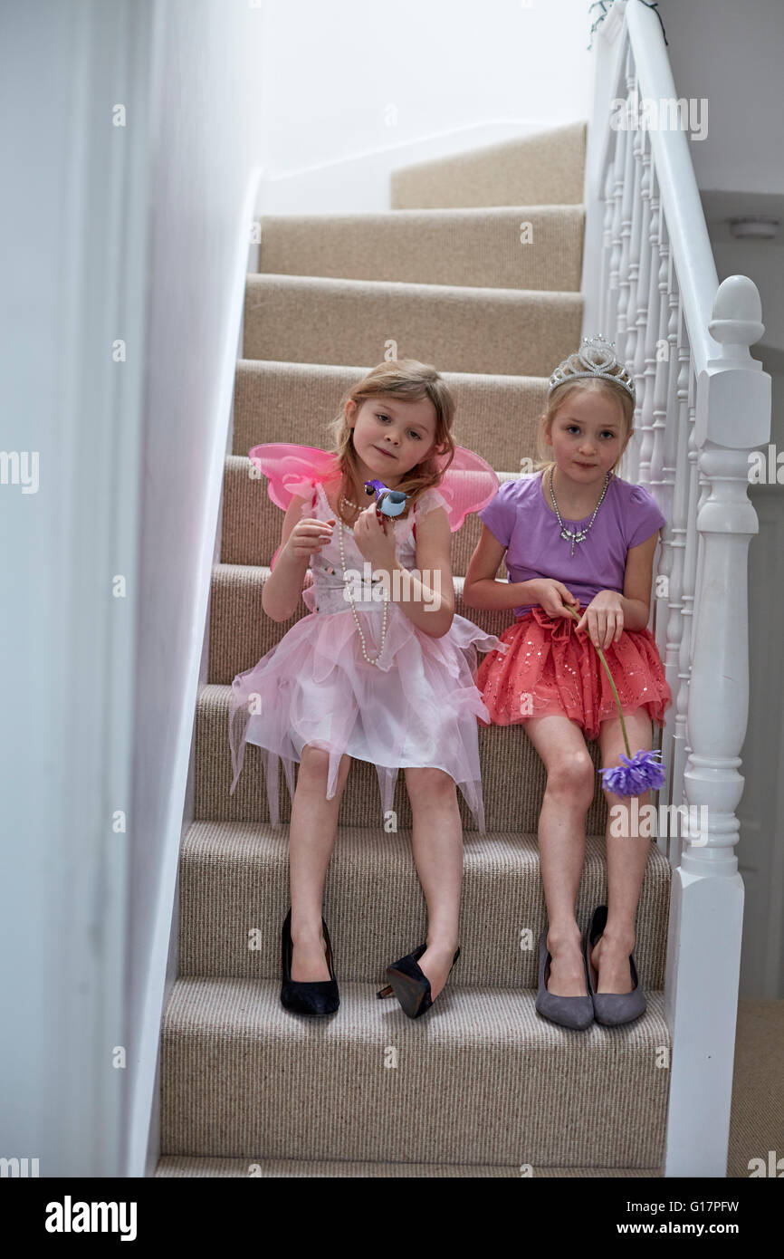 Mädchen in Tracht warten auf Treppe Stockfoto