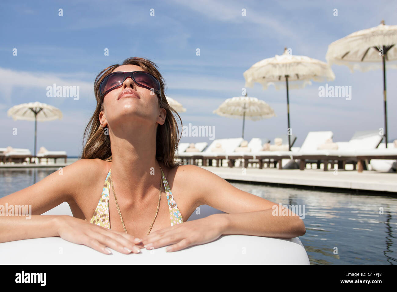Coole junge Frau trage Sonnenbrille gelehnt am Pool im Beach Resort, Mallorca, Spanien Stockfoto