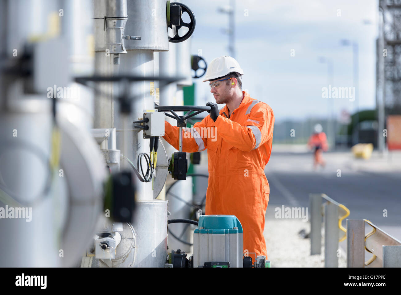 Arbeiter drehen Ventil am Gas-Kraftwerk Stockfoto