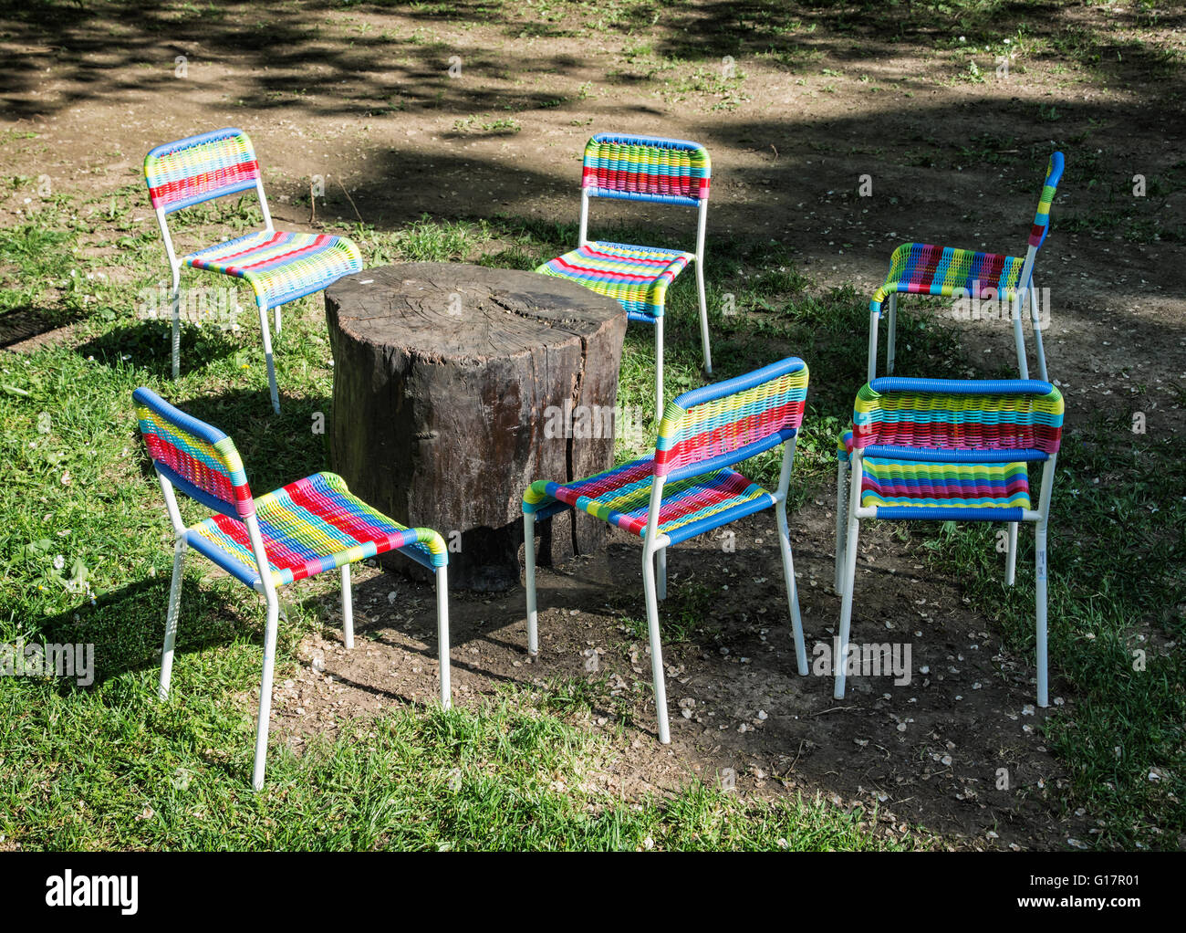 Bunte Stühle und Tisch aus Holz auf dem Rasen. Garten-Party. Licht und  Schatten Stockfotografie - Alamy