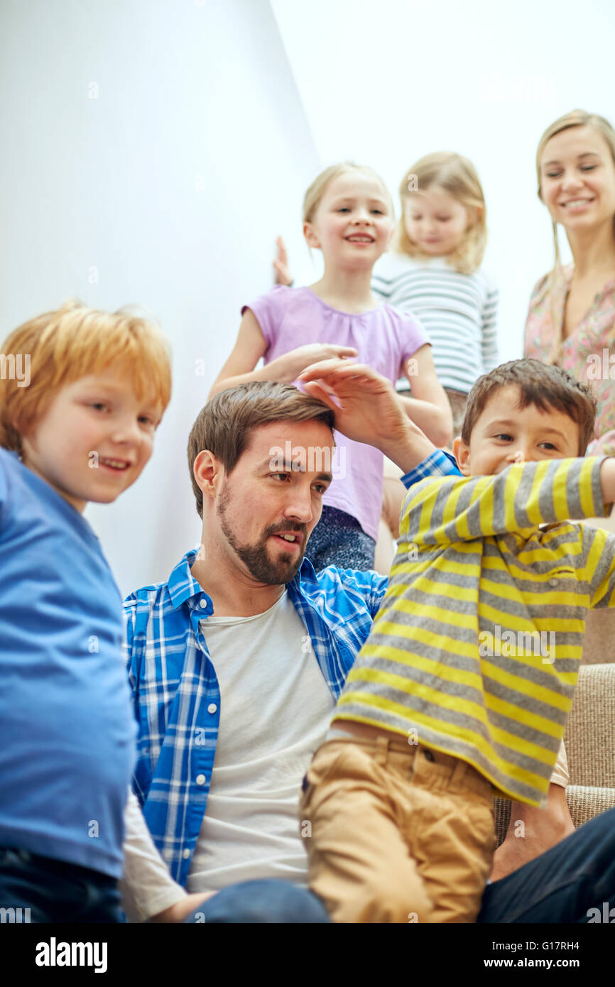 Glückliche Eltern und Kinder sitzen auf der Treppe Stockfoto