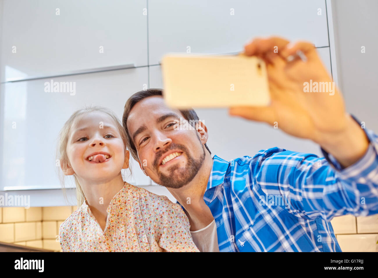 Vater und Tochter nehmen Selfie in Küche Stockfoto