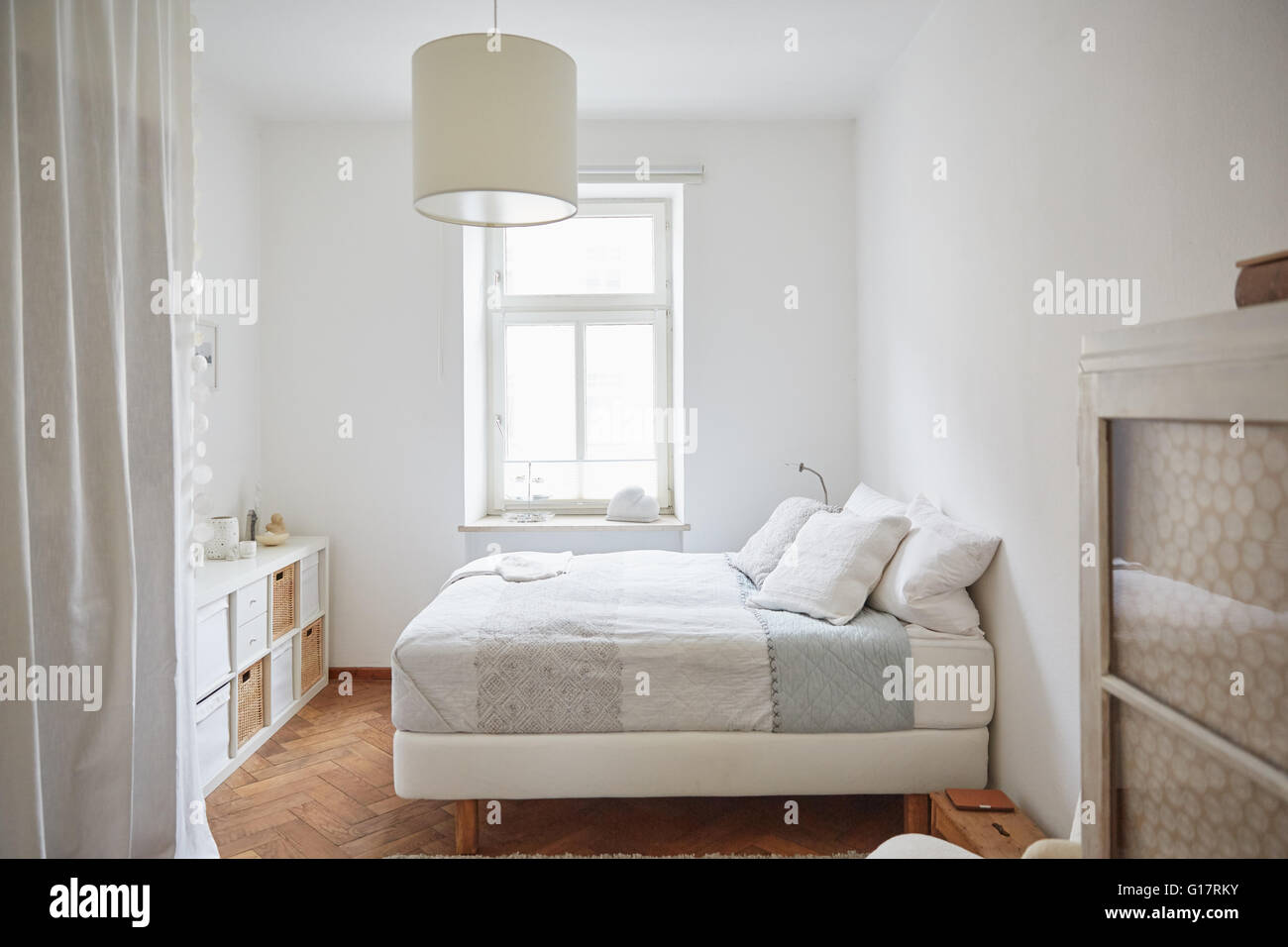 Weiße farbige Schlafzimmer mit Parkettboden, Bett und Schränke Stockfoto