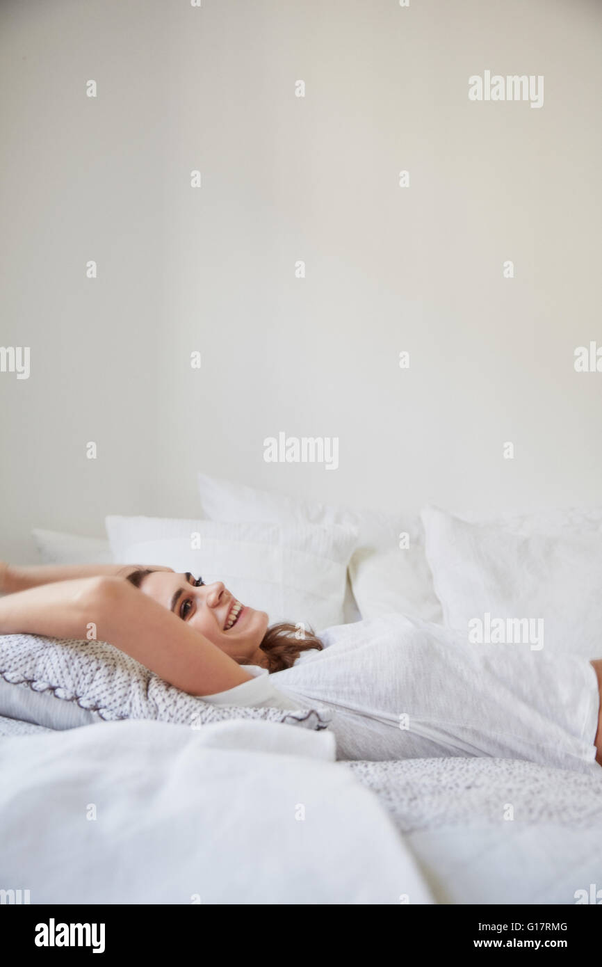 Oberflächenansicht von schönen jungen Frau, die wieder auf dem Bett liegend Stockfoto