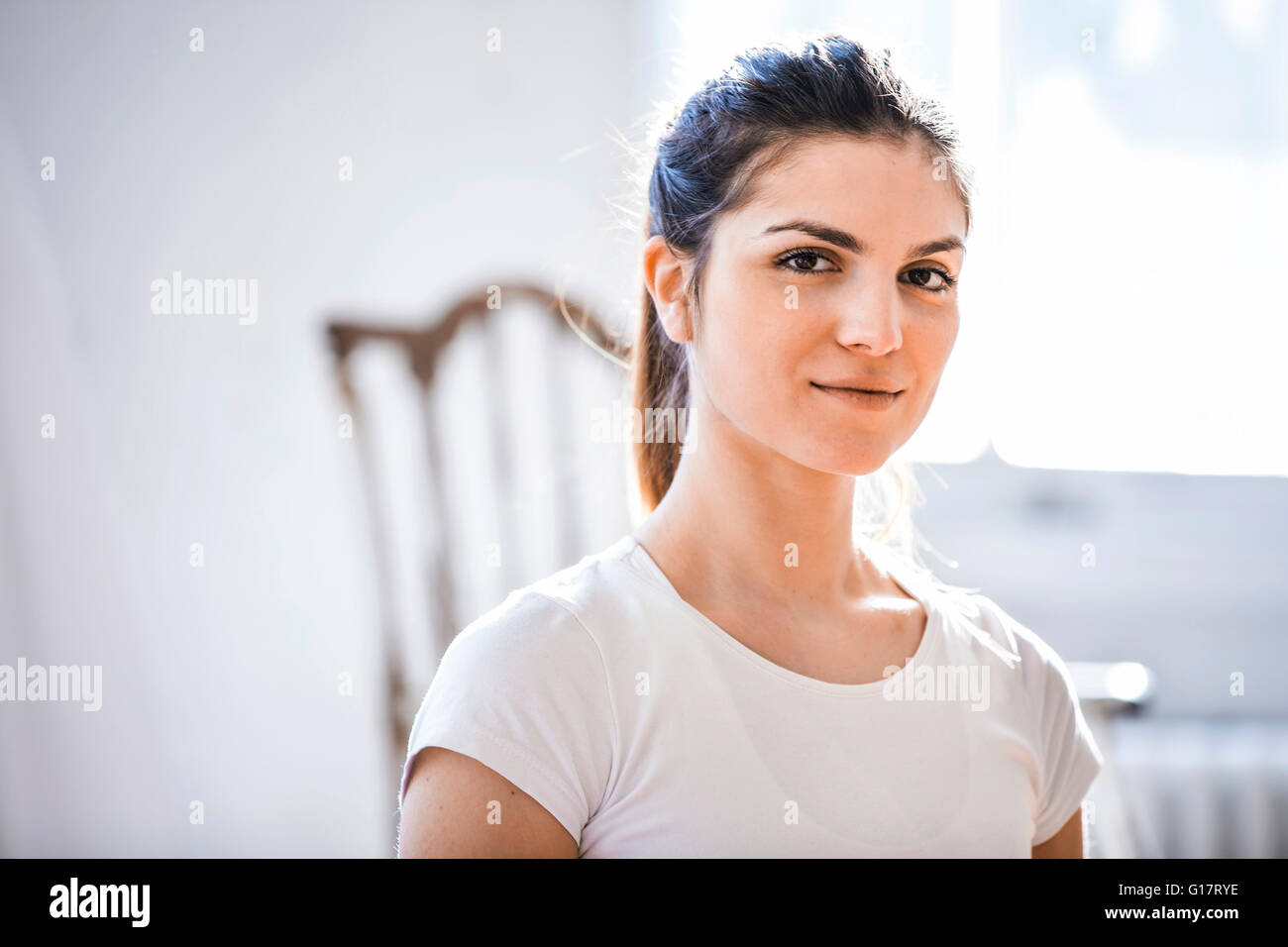 Kopf und Schulter Porträt der schönen jungen Frau in shabby chic Wohnung Stockfoto