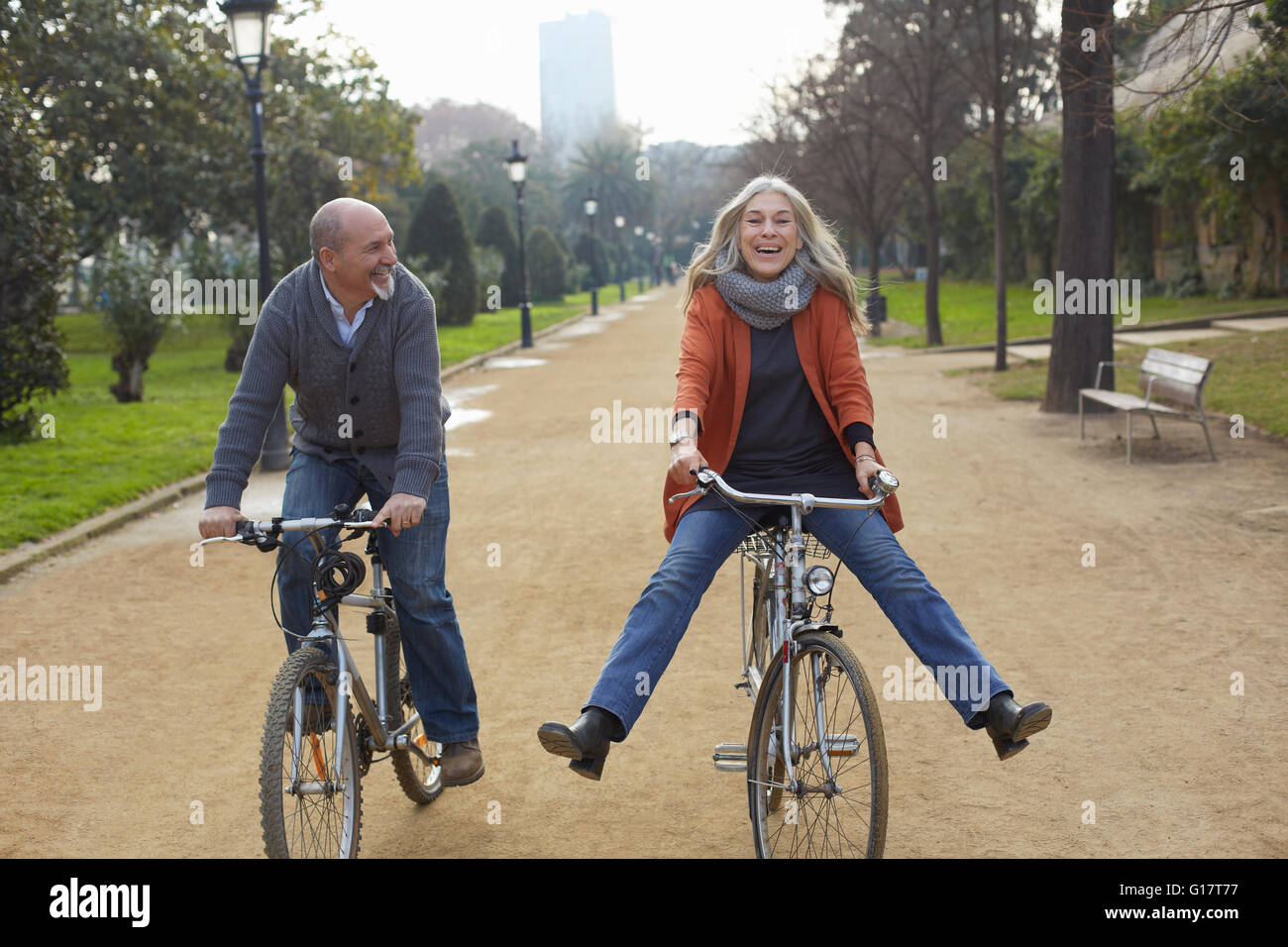 Paar, Fahrrad, von Bäumen gesäumten Weg im Park, Lächeln Stockfoto