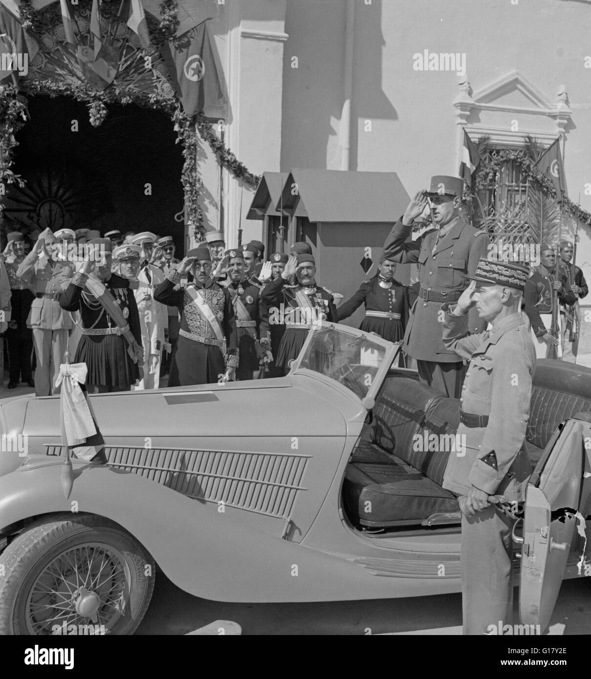 General Charles de Gaulle, begleitet von General Charles Mast, salutieren als Band spielt Marseillaise draußen Sommer Palast des Bey von Tunis, Karthago, Tunesien, Marjorie Collins für Office of War Information, Juni 1943 Stockfoto
