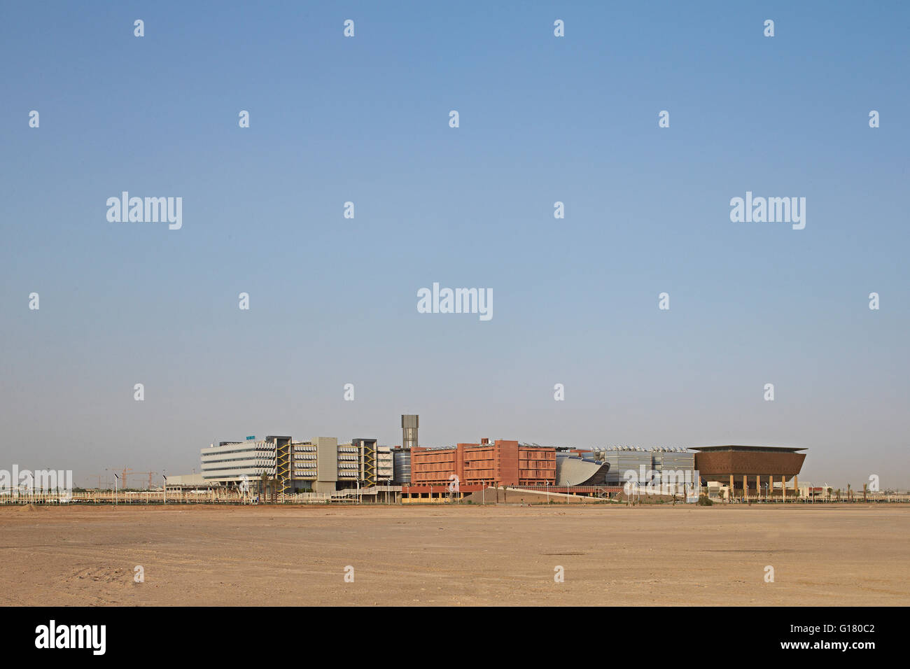 Fernblick von der Wüste zur Stadtentwicklung. Masdar City, Masdar City, Vereinigte Arabische Emirate. Architekt: verschiedene, 2014. Stockfoto