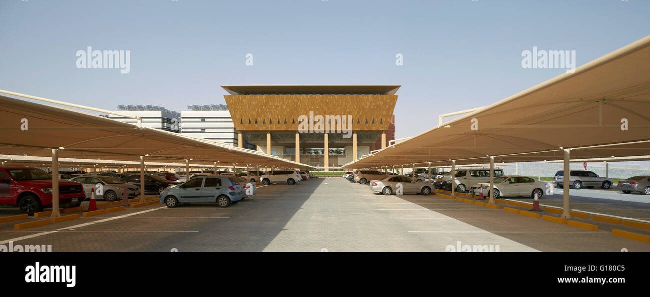Überdachter Parkplatz mit Inkubator Gebäude darüber hinaus. Masdar City, Masdar City, Vereinigte Arabische Emirate. Architekt: verschiedene, 2014. Stockfoto