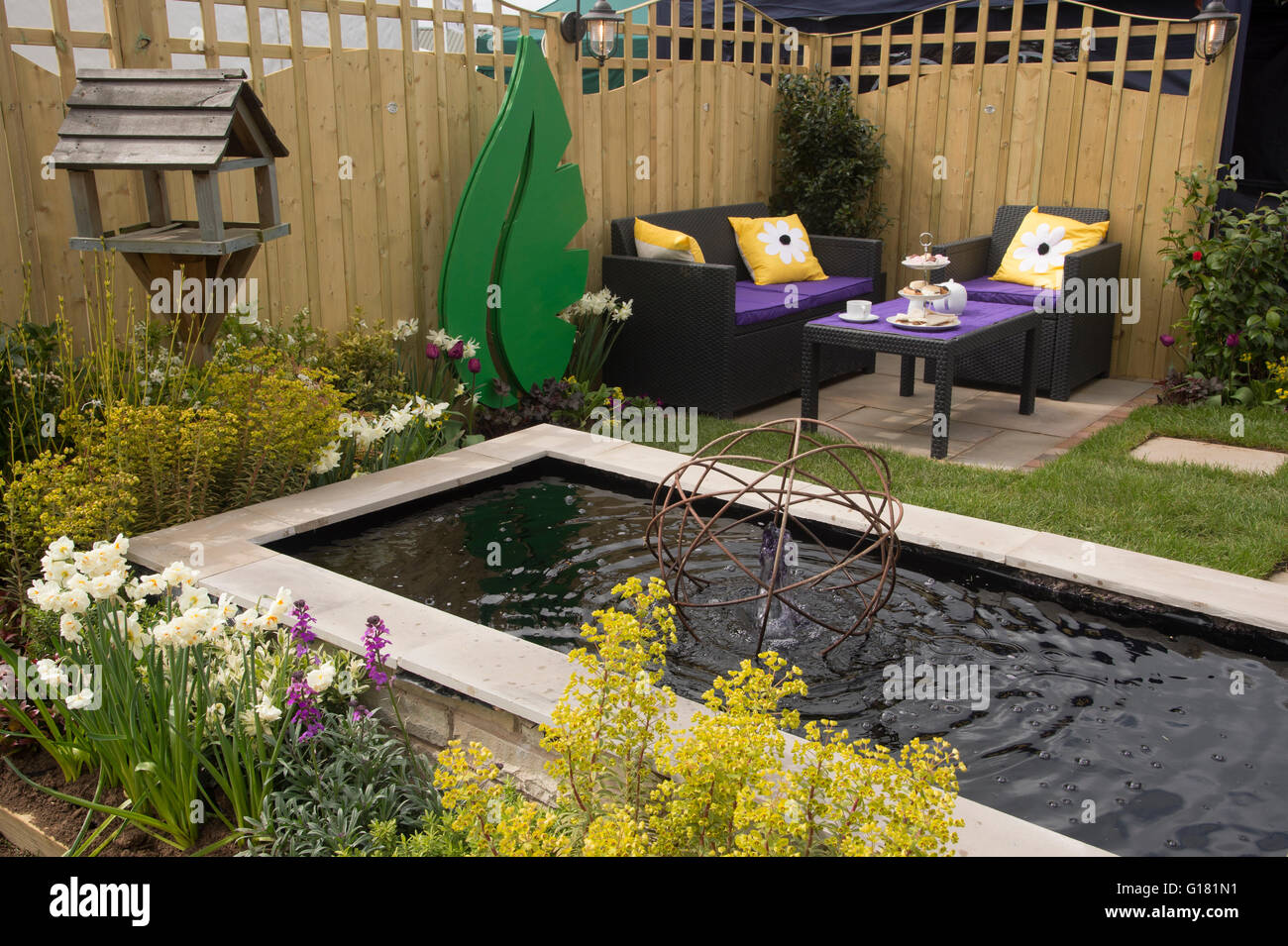 Harrogate Spring Flower Show 2016 North Yorkshire, England) - Wasserspiel (Teich und Brunnen) und Sitzecke im Schaugarten "Relax in Frieden". Stockfoto