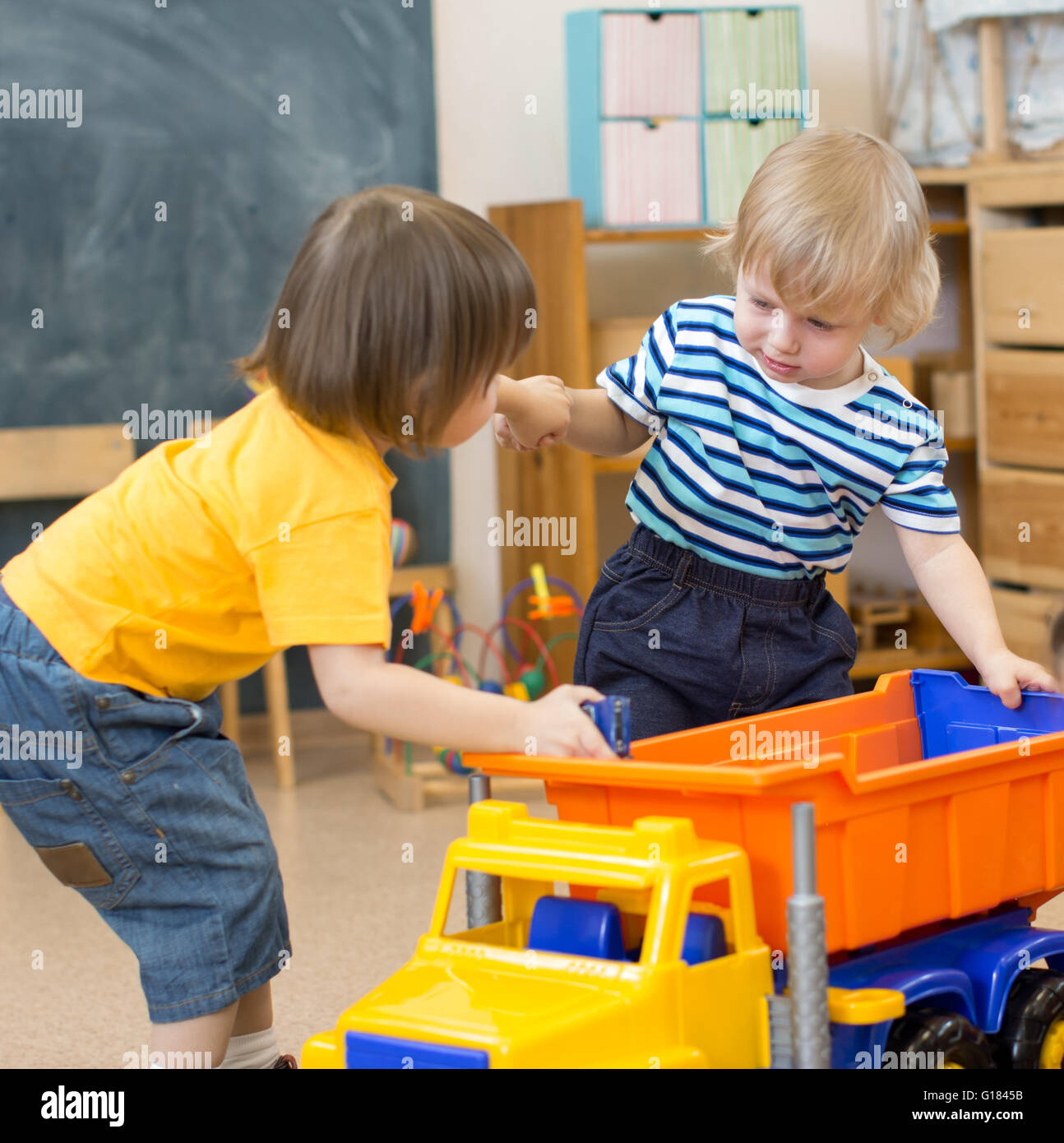 zwei Kinder-Konflikt oder kämpfen für Spielzeug-LKW im kindergarten Stockfoto
