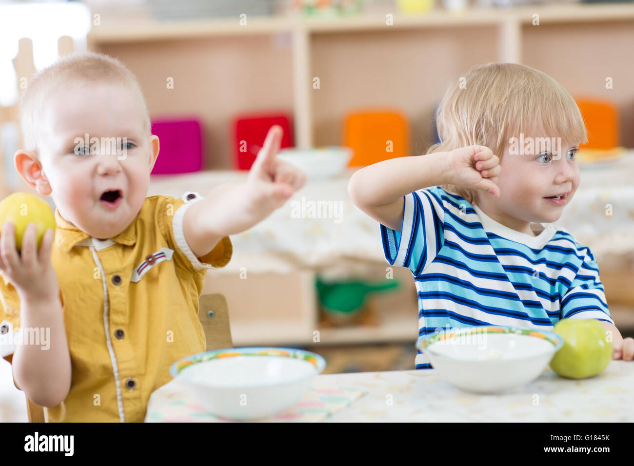 Lustige lächelnden Kinder Fütterung im kindergarten Stockfoto