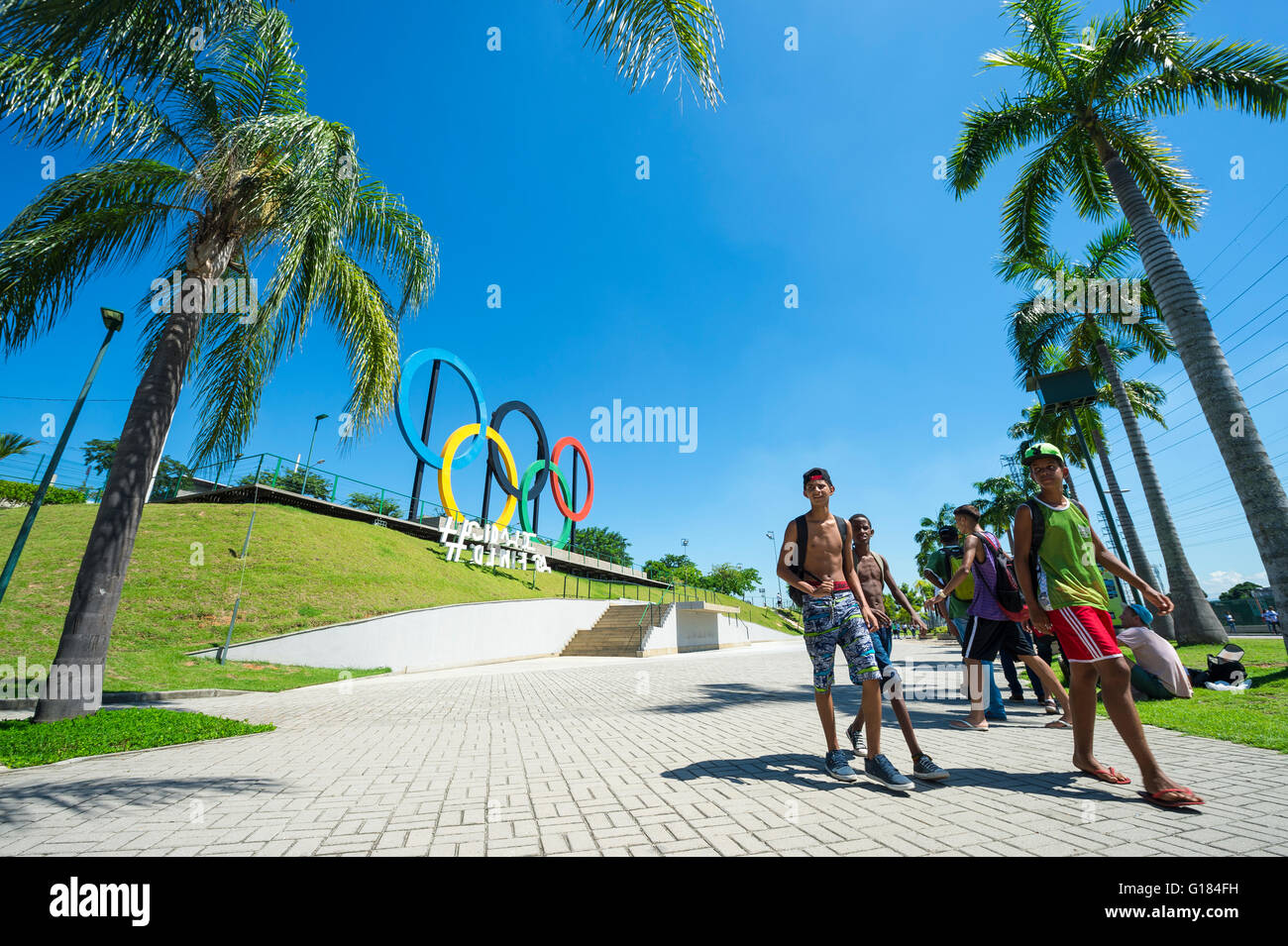 RIO DE JANEIRO - 18. März 2016: Junge Brasilianer laufen Sie vor Olympischen Ringe für die Olympischen Sommerspiele 2016 in einem Park installiert. Stockfoto