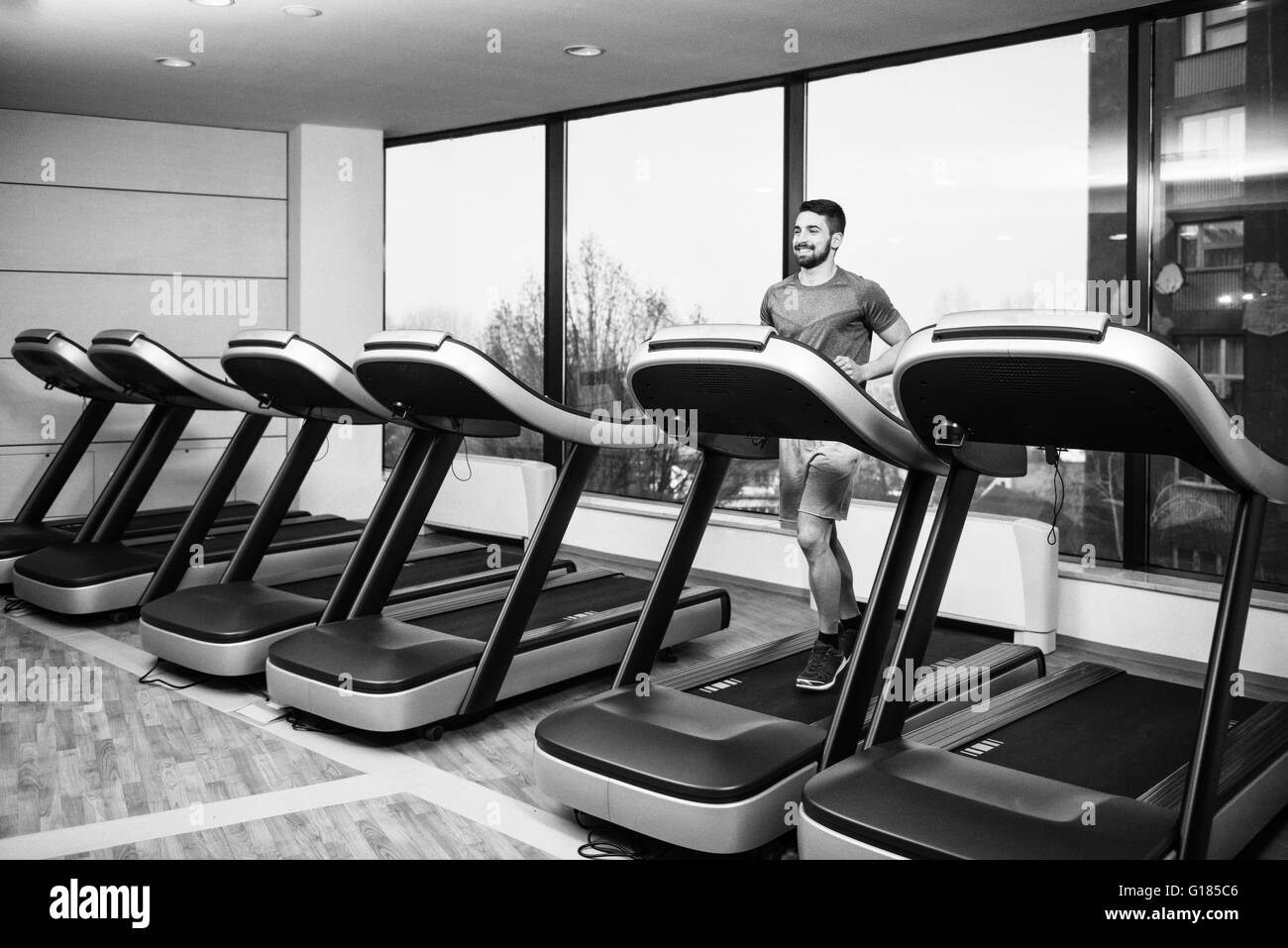 Gut aussehender Mann laufen auf dem Laufband im Fitnessstudio Stockfoto