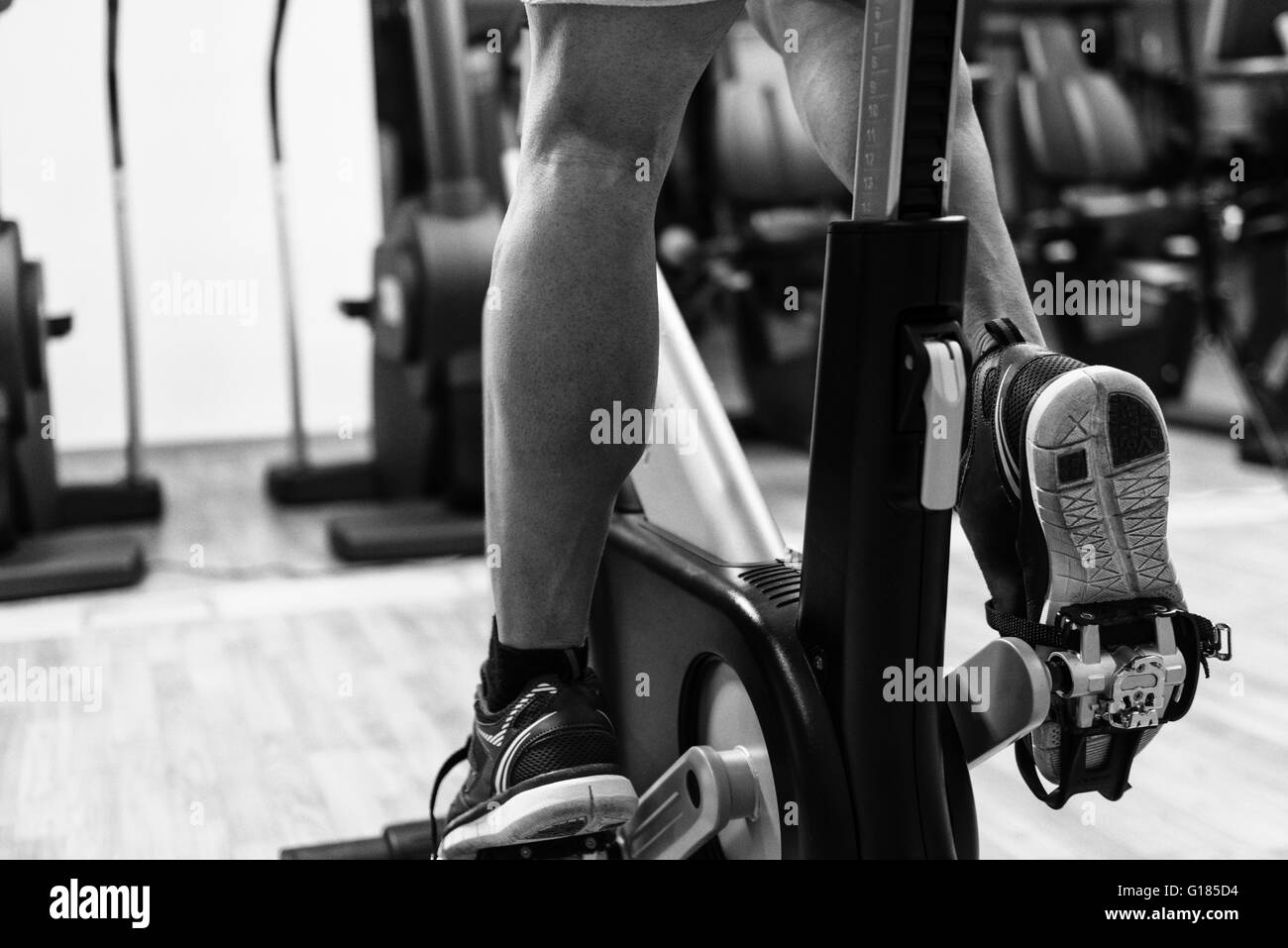 Mann In der Turnhalle - Ausübung seiner Beine tun Cardio-Training auf dem Fahrrad Stockfoto