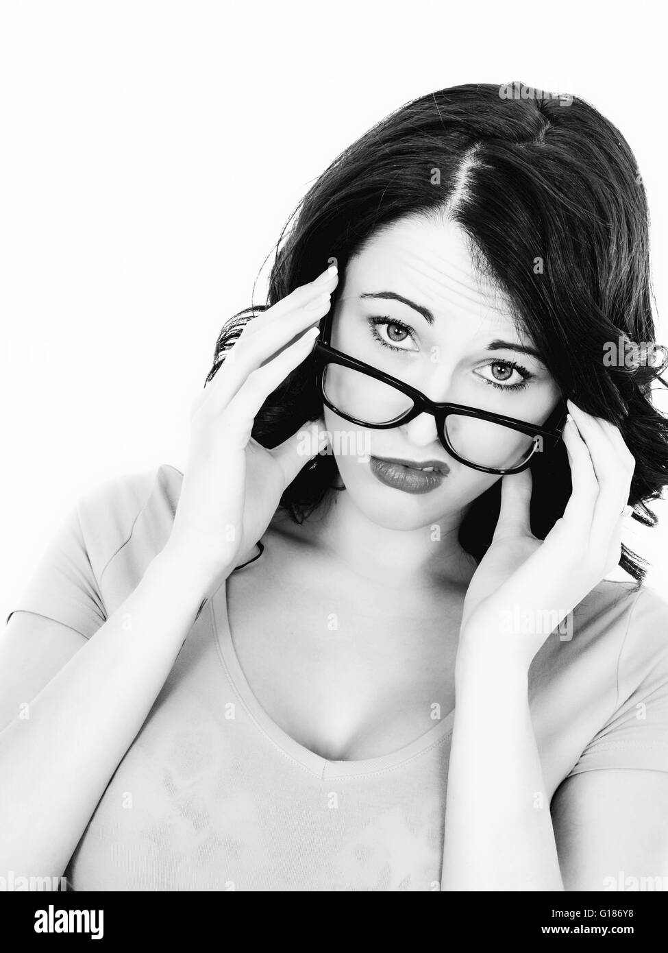 Porträt einer gestresst müde Frau vor einem weißen Hintergrund in die Kamera schaut, über ihr schwarz gerahmte Brille Stockfoto