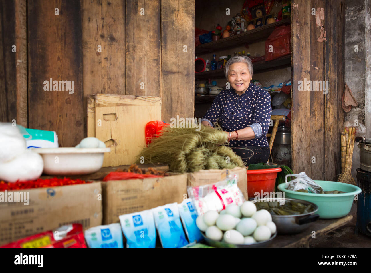 Chinesische Frau Vorbereiten der Nahrung in Ihrem Shop in einem armen alten Nachbarschaft Straße von Nanjing in China. Stockfoto