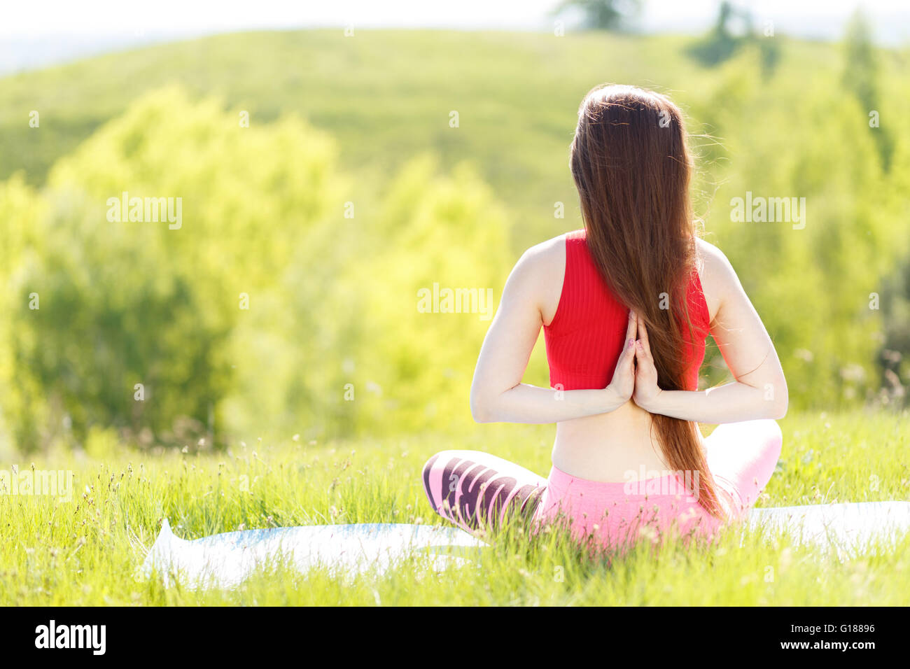 Junge Frau praktizieren Yoga posiert im Freien. Namaste Lotus Pose. Meditation und Entspannung Stockfoto