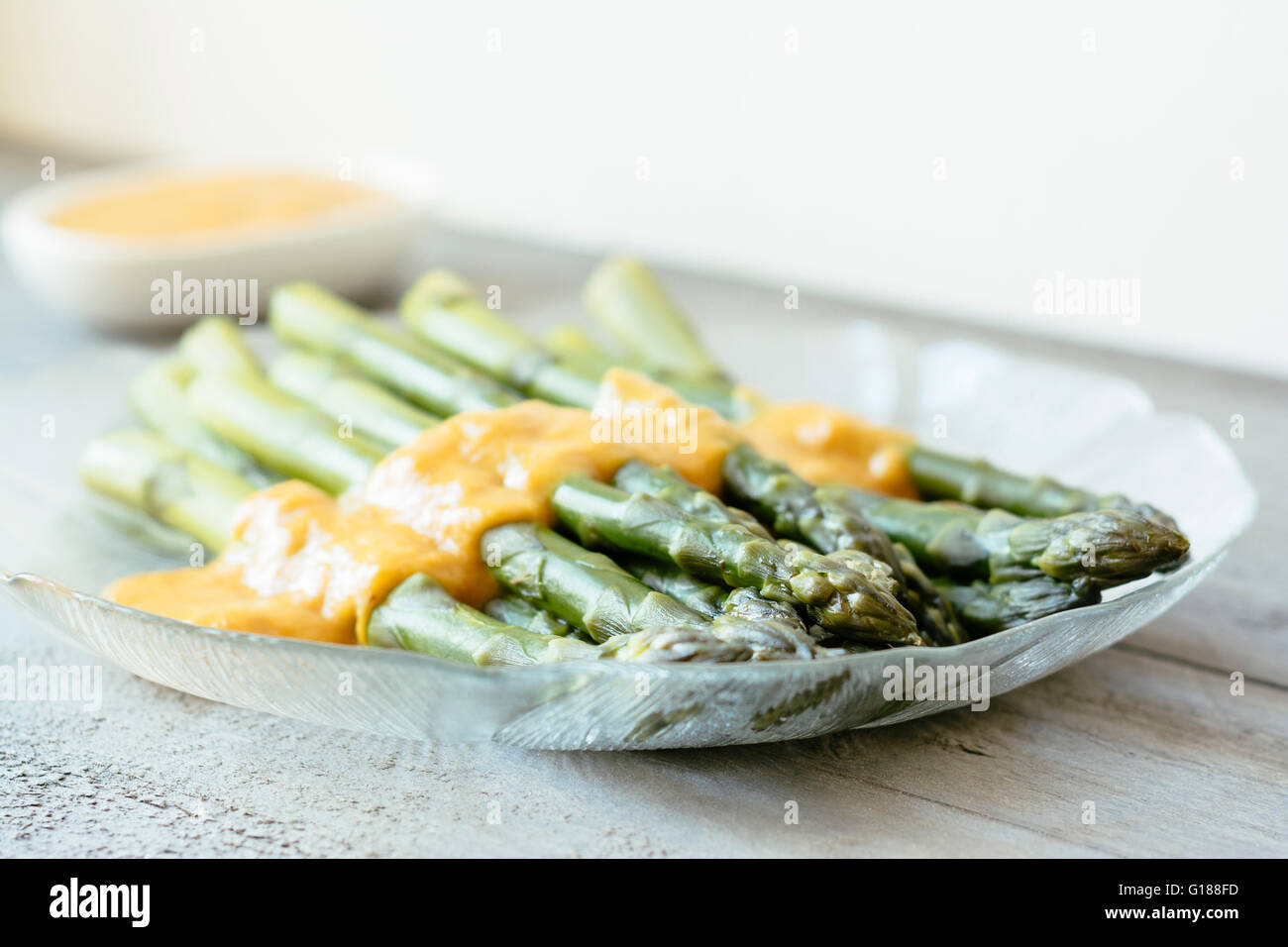 Grüner Spargel mit Rhabarber-Senf-Sauce. Stockfoto