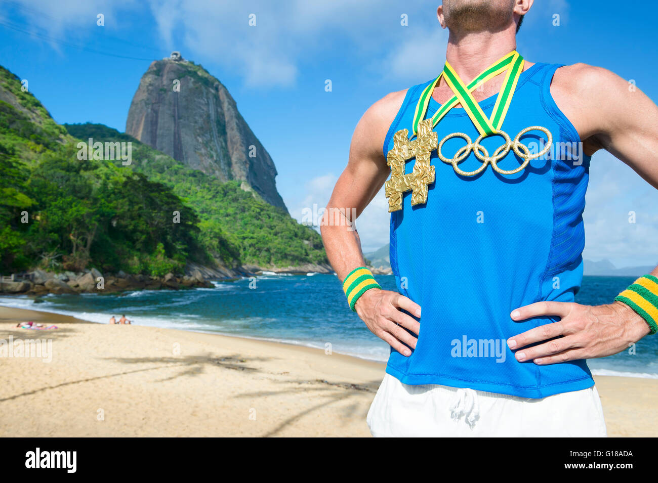 RIO DE JANEIRO - 10. März 2016: Athlet steht mit Olympischen Ringen gold Medaille mit Hashtag am Strand am Zuckerhut. Stockfoto