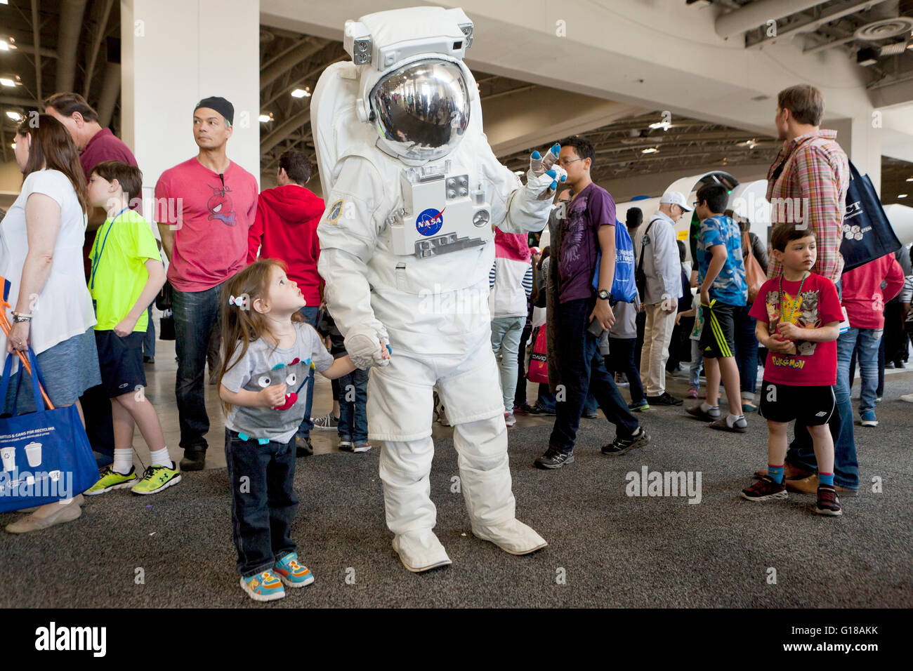 Kleine Mädchen posiert für ein Foto mit Imitator "Astronaut" Science fair - USA Stockfoto