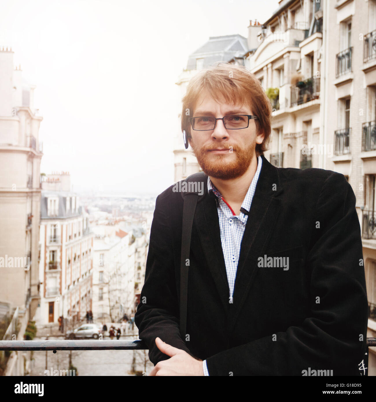 Schön ruhig bärtiger Mann tragen Kopfhörer in Paris, Frankreich in die Kamera schauen. City-Lifestyle. Bild getönt. Stockfoto