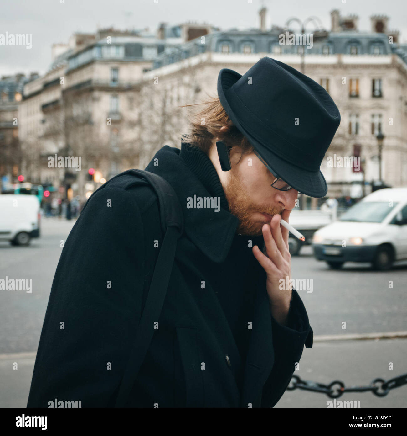 Attraktive bärtiger Mann tragen Hut Rauchen auf der Straße in europäischen Stadt Stockfoto