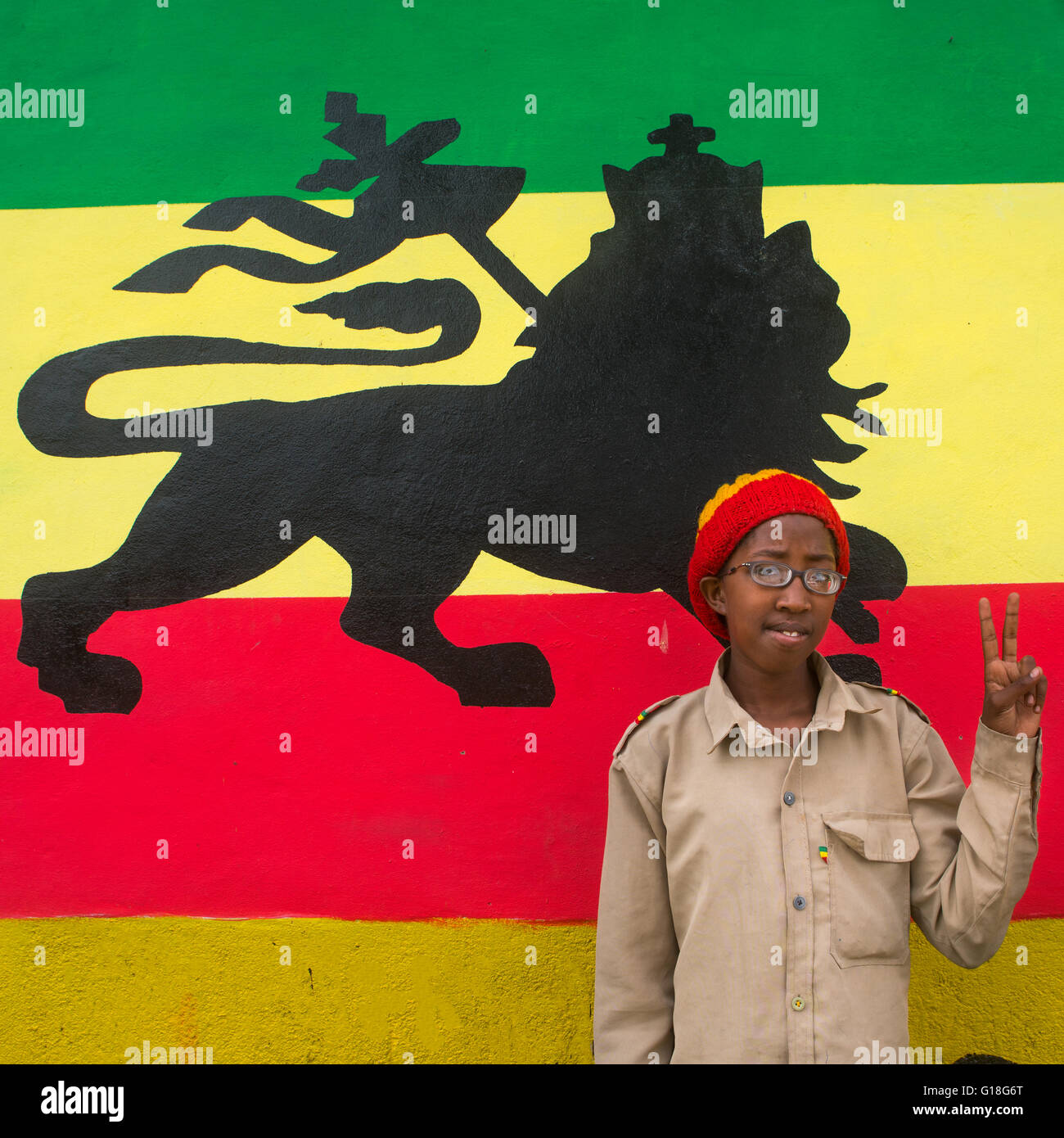 Rastafari Mädchen namens Kizzy vor einem Löwen von Juda Wandbild, Oromo, Shashamane, Äthiopien Stockfoto