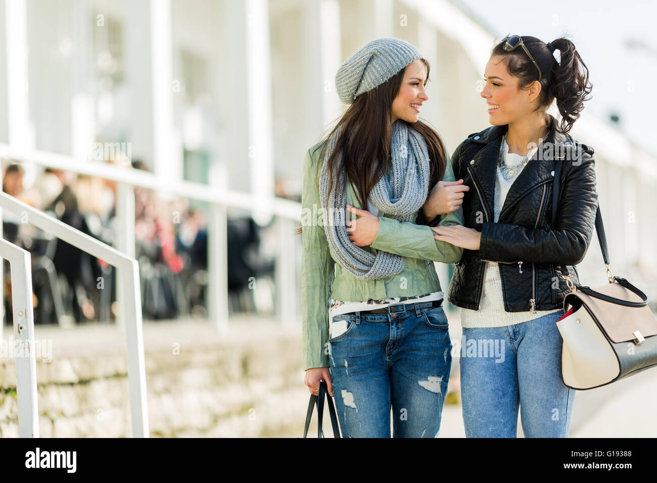 Zwei junge Frauen zu Fuß und shopping glücklich beim betrachten einander Stockfoto