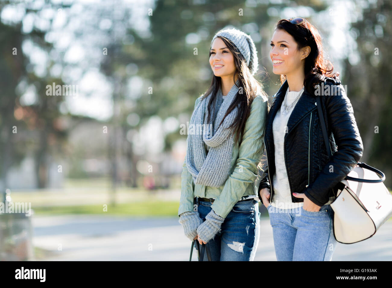 Zwei junge Frauen, ein Spaziergang im Park und glücklich lächelnd Stockfoto