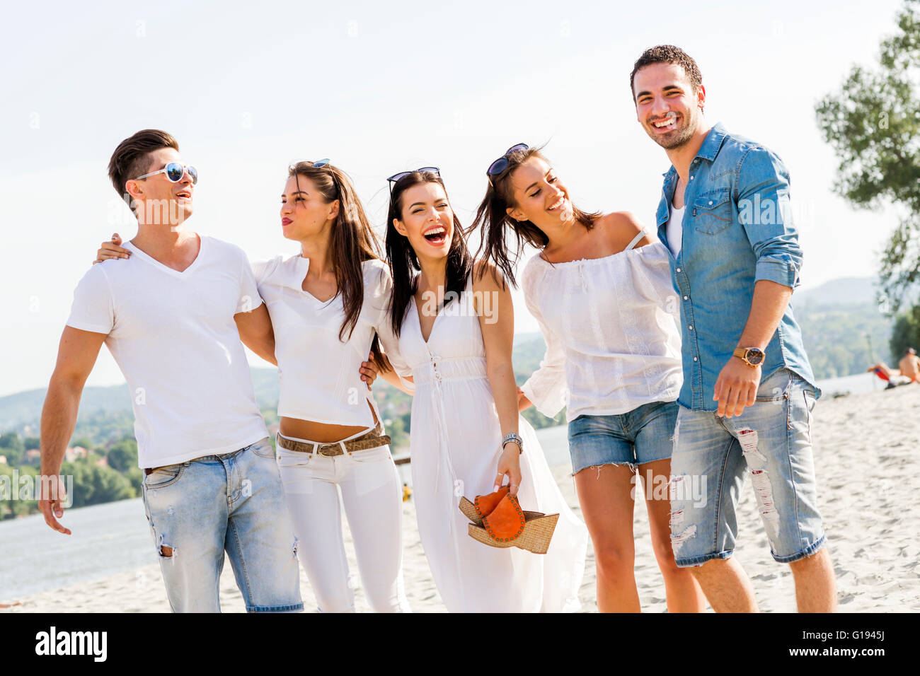 Gruppe von Jugendlichen, die Hand in Hand am Strand als Zeichen der Freundschaft Stockfoto