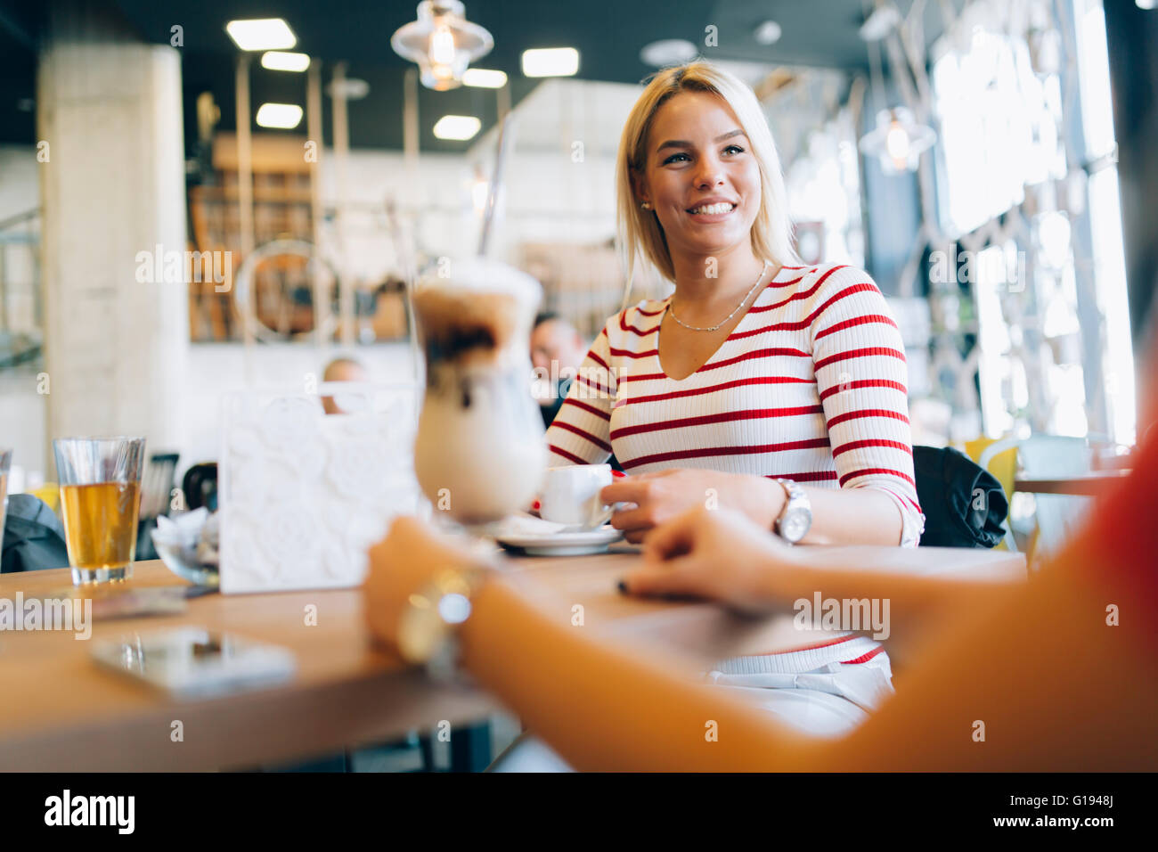 Schöne Frauen, Kaffeetrinken und tratschen in netten restaurant Stockfoto
