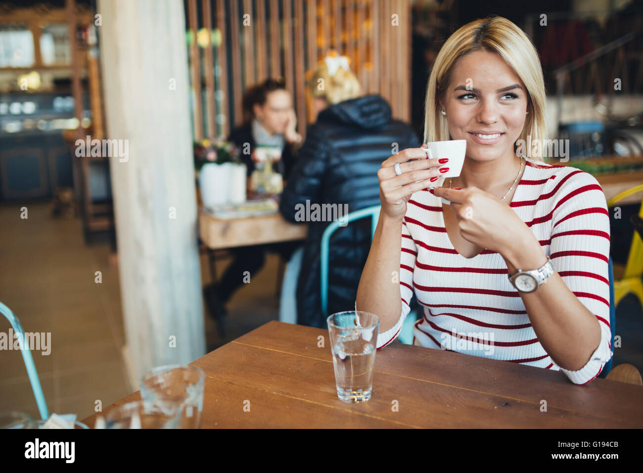 Schöne Frau in einem hölzernen Café Kaffee trinken Stockfoto