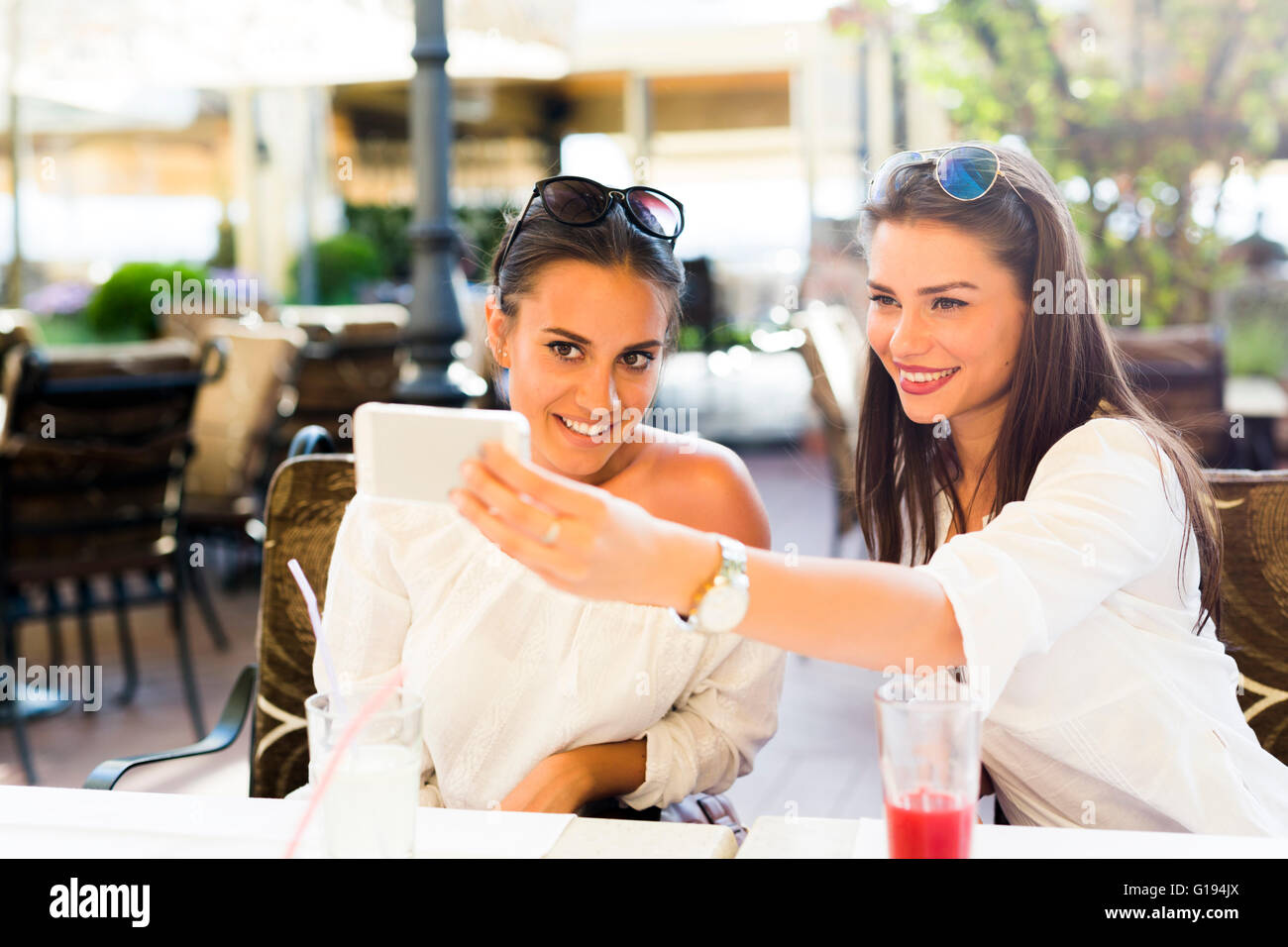 Zwei junge schöne Frauen, die eine Selfie von sich selbst in der Mittagspause Stockfoto