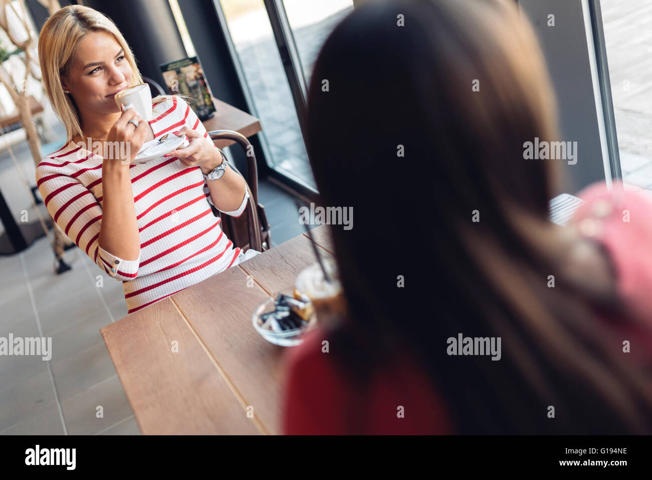 Schöne Frauen, Kaffeetrinken und tratschen in netten restaurant Stockfoto